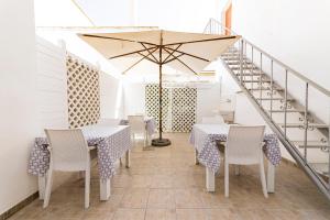a dining room with tables and chairs and an umbrella at InCentro b&b in Porto Cesareo