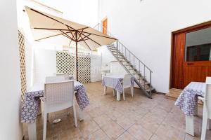 a dining room with tables and chairs and an umbrella at InCentro b&b in Porto Cesareo +11 photos
