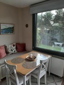 una mesa y sillas en una sala de estar con ventana en studio yannis leonidas, en Asprókhoma