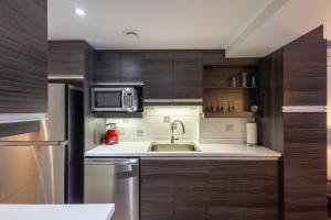 eine Küche mit Spüle und Mikrowelle in der Unterkunft Les Immeubles Charlevoix - Le 1166 in Québec + 8 Fotos