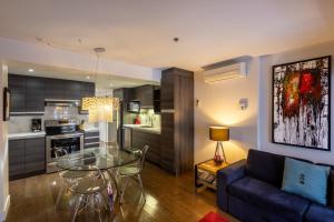 ein Wohnzimmer mit einem Glastisch und einer Couch in der Unterkunft Les Immeubles Charlevoix - Le 1166 in Québec