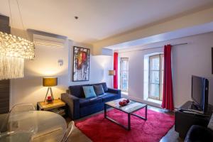 ein Wohnzimmer mit einer blauen Couch und einem Fernseher in der Unterkunft Les Immeubles Charlevoix - Le 1166 in Québec