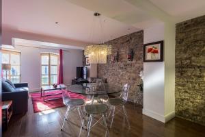 ein Esszimmer und ein Wohnzimmer mit Tisch und Stühlen in der Unterkunft Les Immeubles Charlevoix - Le 1166 in Québec