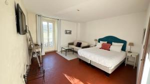 ein Schlafzimmer mit einem Bett und einer Couch in der Unterkunft Logis Hôtel la Vallée de l'Arc in Trets