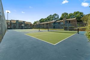 einen Tennisplatz vor einigen Apartmentkomplexen in der Unterkunft Landing Apartments - Denton in Denton