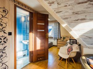 een kamer met een trap, een witte stoel en een badkamer bij WERONIKA Murzasichle in Murzasichle