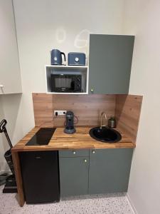 a small kitchen with a sink and a microwave at Appartement Central avec Jacuzzi Privé I Strasbnb in Strasbourg +6 photos