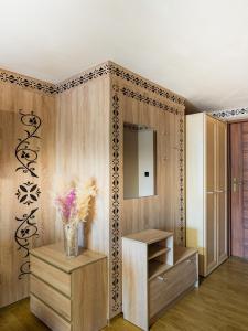 een kamer met een kast met een vaas met bloemen bij WERONIKA Murzasichle in Murzasichle
