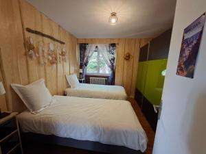 ein Schlafzimmer mit zwei Betten und einem Fenster in der Unterkunft L'Écrin du Poten'Ciel in Allègre