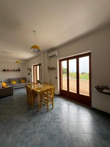 Una sala de estar con una mesa y sillas y un sofá. en B&B Il Giardinetto, en Ardore Marina