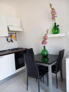 une cuisine avec une table et deux vases verts remplis de fleurs dans l'établissement casa Leonardo, à Pizzo 30 autres photos