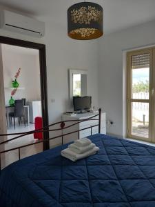 une chambre avec un lit bleu avec un bureau et une fenêtre dans l'établissement casa Leonardo, à Pizzo