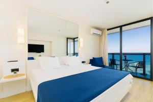a bedroom with a blue and white bed and a balcony at ORBI CITY - Black Sea Apartments in Batumi +58 photos