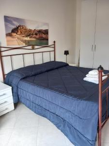 - un lit avec une couette bleue dans une chambre dans l'établissement casa Leonardo, à Pizzo