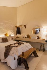 a bedroom with a bed with a table and a sink at Mōmento Itamambuca in Ubatuba