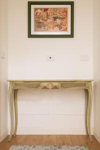 a console table against a white wall with a picture above it at Casa Tanina in Bitonto +16 photos
