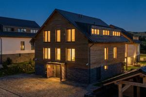 ein großes Holzhaus mit eingeschaltetem Licht in der Unterkunft LUXURY SUITE Boží Dar in Boží Dar