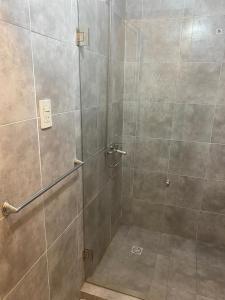 une douche avec une porte en verre dans une salle de bain dans l'établissement Libertad, à Clorinda