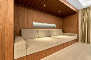 eine Couch in einem Raum mit Holzwänden in der Unterkunft LUXURY SUITE Boží Dar in Boží Dar