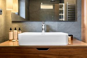 ein weißes Waschbecken in einem Badezimmer mit einem Spiegel in der Unterkunft LUXURY SUITE Boží Dar in Boží Dar + 8 Fotos