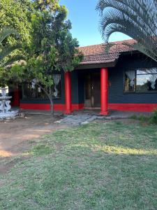 una casa con colonne rosse sul lato di Protea Guesthouse a Phalaborwa