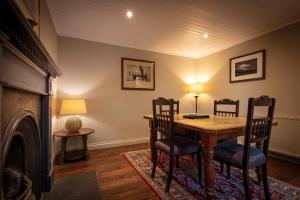 een eetkamer met een tafel en stoelen en een open haard bij Dunvegan Castle Rose Valley Cottage in Dunvegan