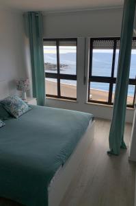una camera con letto e vista sulla spiaggia di Pópulo Mar a Ponta Delgada