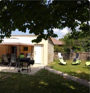 ein Haus mit Stühlen und einem Grill im Hof in der Unterkunft Heviz Holiday House in Hévíz