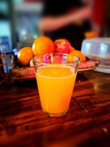 a glass of orange juice sitting on top of a table at Katana Capsule Hostel in Mendoza