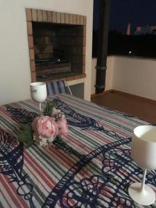a bed with two flowers and a candle on it at Casa Praia Verde V3 in Castro Marim +9 photos