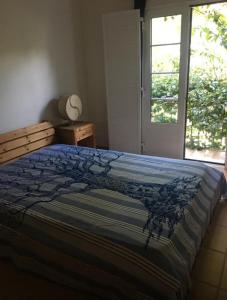 a bedroom with a bed with a blue comforter and a window at Casa Praia Verde V3 in Castro Marim