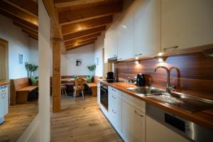 a kitchen with white cabinets and a sink and a table at Appartement Omesberg 1 in Lech am Arlberg