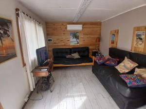 a living room with a black leather couch and a desk at TerraNostra in Mar de Cobo