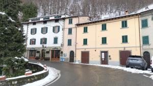 een groep gebouwen op een besneeuwde straat bij Casa Vacanza Bettega in Pianosinatico