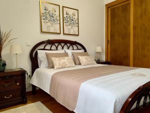 a bedroom with a large bed with two pictures on the wall at Casa Vista para a Serra in Casais do Livramento