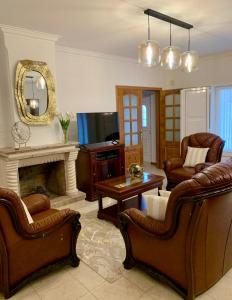 a living room with leather furniture and a fireplace at Casa Vista para a Serra in Casais do Livramento