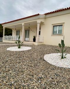 a house with two plants in front of it at Casa Vista para a Serra in Casais do Livramento