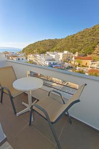 Ein Tisch und Stühle auf einem Balkon mit Aussicht in der Unterkunft Lefka Ori - Agia Galini in Agia Galini