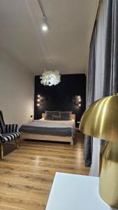 a bedroom with a bed and a black wall at Black Room Apartment in Mukacheve