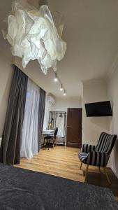 a room with a bed and a table and a chandelier at Black Room Apartment in Mukacheve