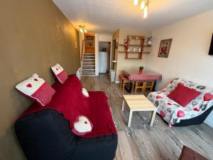 Appartement Résidence Cortina3 في بوي-سانت-فينسينت: غرفة معيشة بها أريكة وطاولة