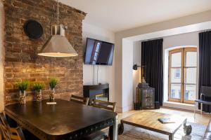 a dining room with a table and a brick wall at Les Immeubles Charlevoix - Le 1168 in Quebec City