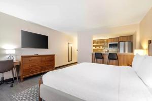 a hotel room with a large bed and a flat screen tv at The Quincy, an Ascend Collection Hotel in Washington