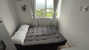 a couch sitting in a room with a window at Apartamento frente a la montaña en Armenia Quindio - 1 Dormitorio Piso 11 in Armenia
