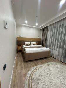 a bedroom with a large bed and a rug at Tour House in Tridtsatʼ Let Kazakhstana +11 photos