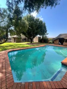 a large swimming pool with a tree in the background at Country Farm House in Delmas