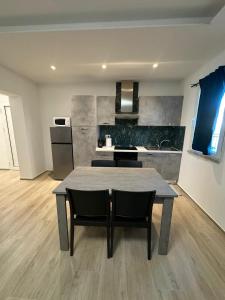 a kitchen with a table and chairs in a room at Appartamenti Cataleya in Cuccurano +6 photos