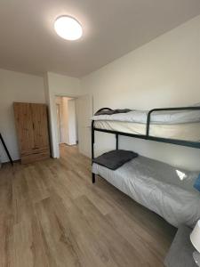 Una habitación con dos literas y suelo de madera. en Appartamenti Cataleya, en Cuccurano