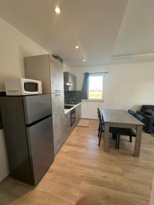 cocina y comedor con mesa y microondas en Appartamenti Cataleya, en Cuccurano