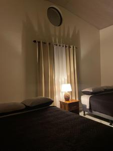 a bedroom with two beds and a lamp on a table at Baruch Tropical Ranch in Los Santos